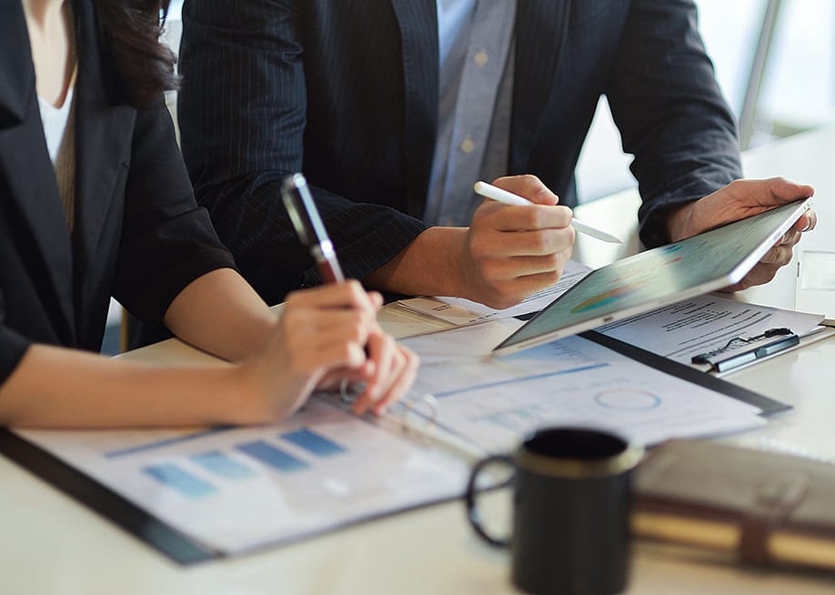 Finance teammates working together on a business process using digital data and graphs. — BongkarnGraphic // Shutterstock