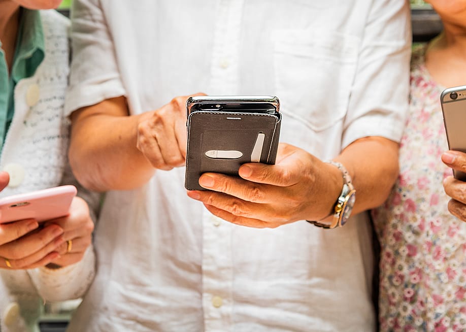People using and sharing their smartphones' content with each other. — Rawpixel.com // Shutterstock
