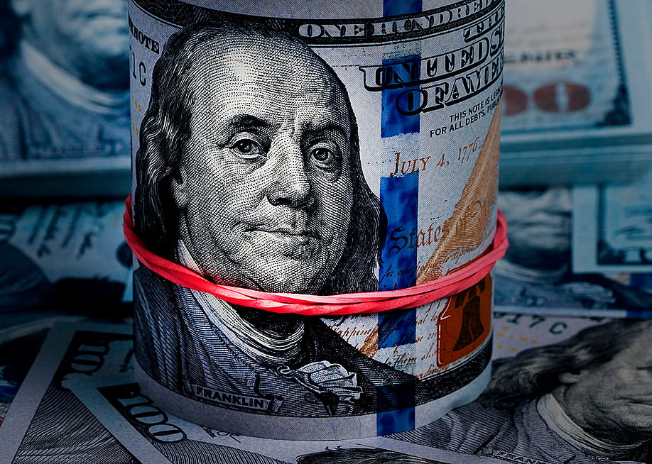 Close up on a rolled band of US dollar banknotes. — Aleksandrkozak // Shutterstock