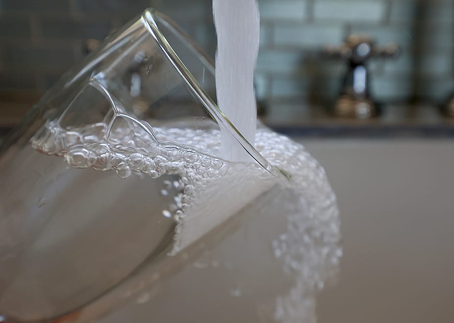 Water running from a kitchen faucet to fill a glass. — Joe Raedle // Getty Images