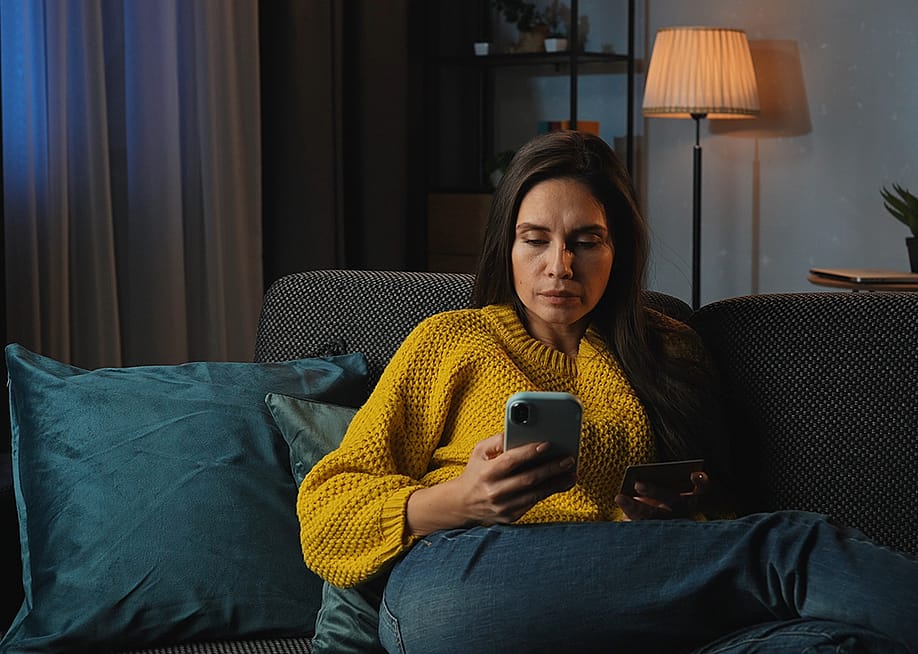 A middle-aged woman at home purchasing online using her credit card. — KinoMastersKaya // Shutterstock