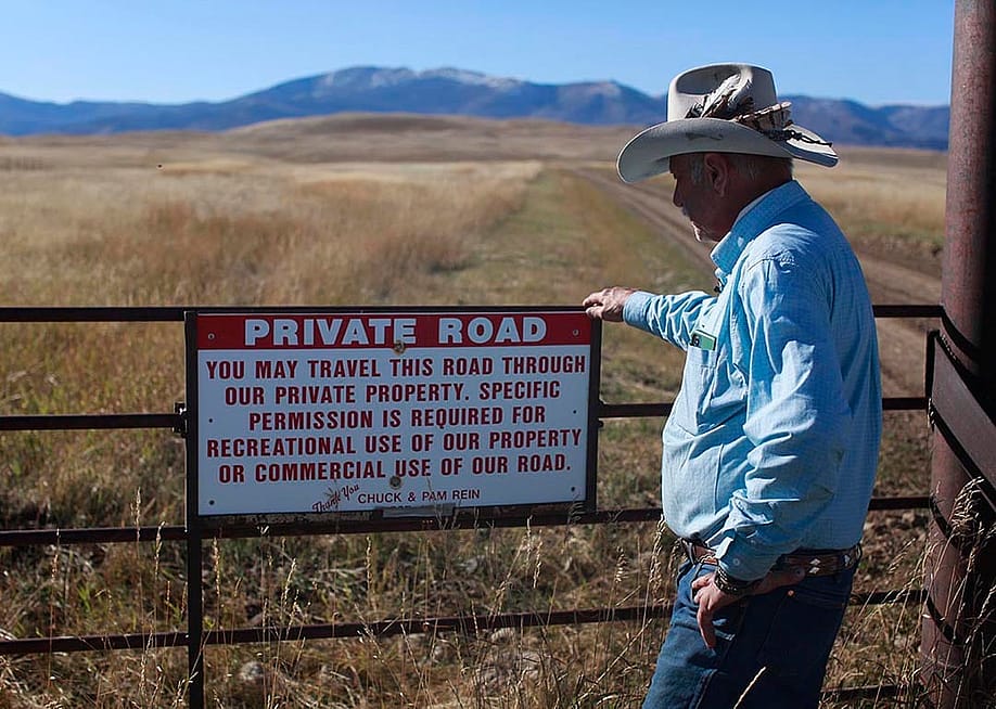 Brad Wilson stands beside a dirt road that leads to a century-old public trail that was abandoned by the U.S. Forest Service as part of a controversial land swap. — Evan Simon // Floodlight