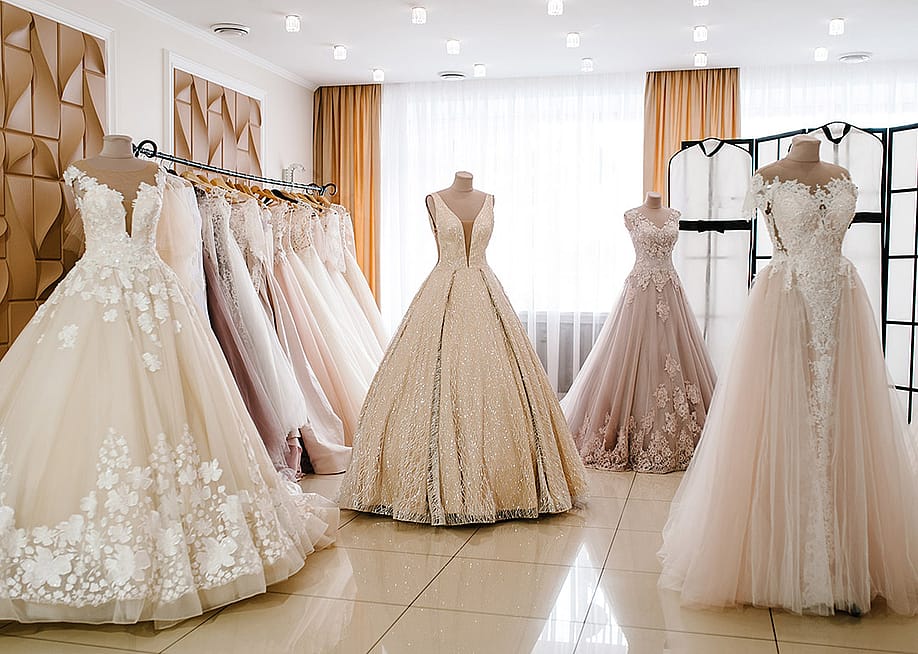 Wedding dresses on hangers and mannequins displayed in a bridal studio. — Sergii Sobolevskyi // Shutterstock