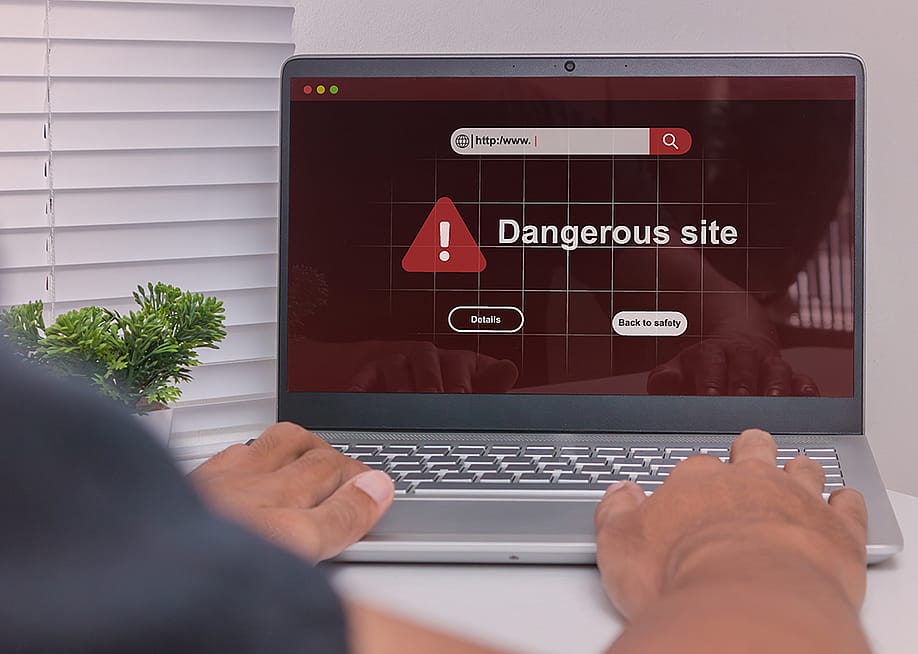 A dangerous site warning displayed on a laptop. — fadfebrian // Shutterstock