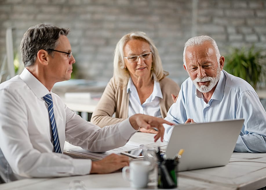 A senior couple having a meeting with a financial advisor. — Drazen Zigic // Shutterstock