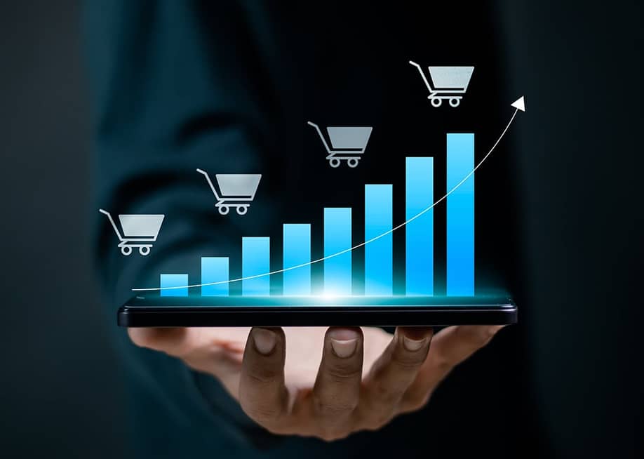 Person holding a device projecting a digital bar chart depicting growing sales. — A9 STUDIO // Shutterstock