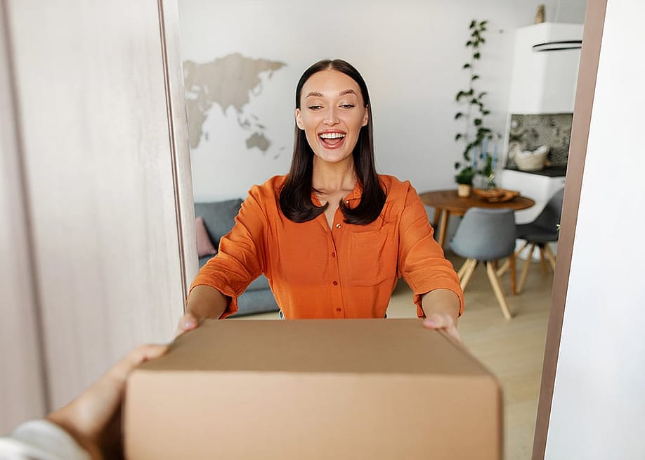 A happy woman receiving a package. — fast-stock // Shutterstock