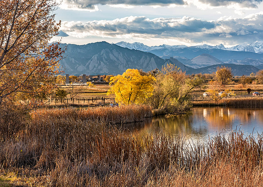 Flatirons and mountain ranges seen behind the Stearns Lake in an autumn landscape in Broomfield, Colorado, USA. — Colin D. Young // Shutterstock