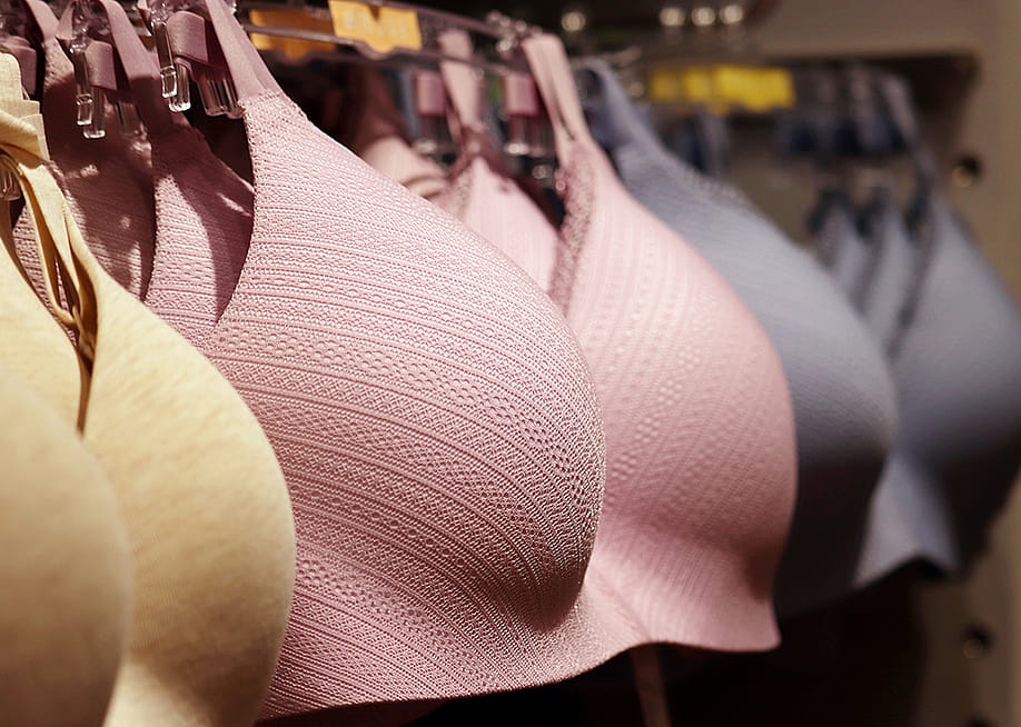 Different sizes and colors of wireless bras on a lingerie store rack. — Oleg Elkov // Shutterstock