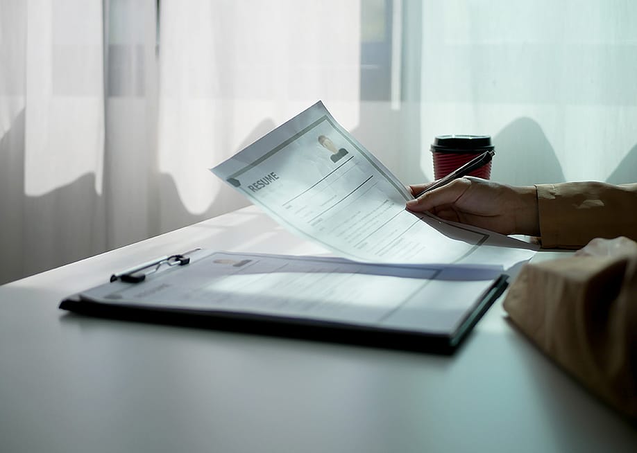 An HR professional reviewing a resume. — Ple Kulnipa // Shutterstock