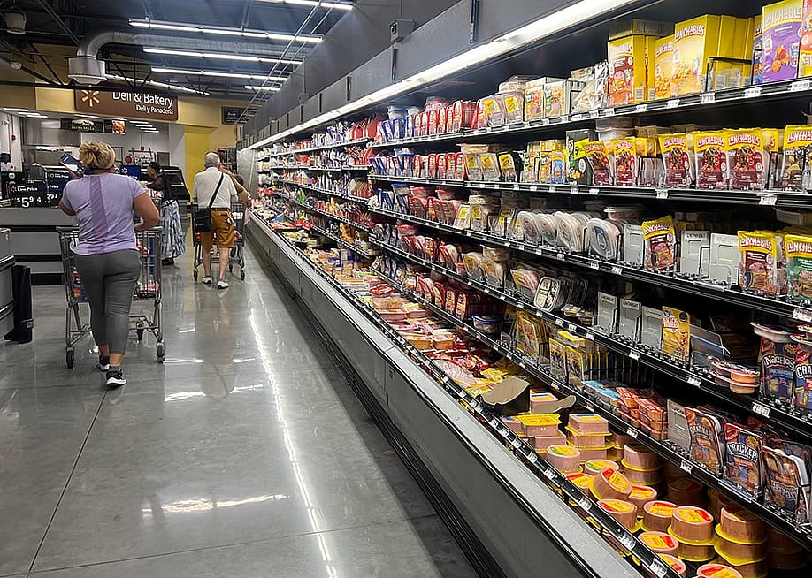 Customers shop in the deli meat aisle of a grocery store in Miami, Florida. — Joe Raedle // Getty Images