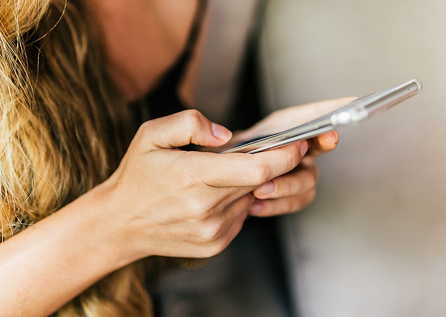 A woman texting on her phone. — Tayler Derden // Shutterstock