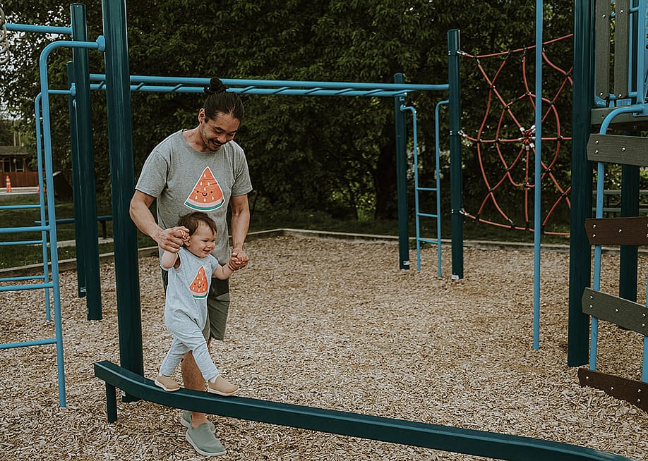 A father and his son bonding together in a playground. — Gabriela Le // Shutterstock