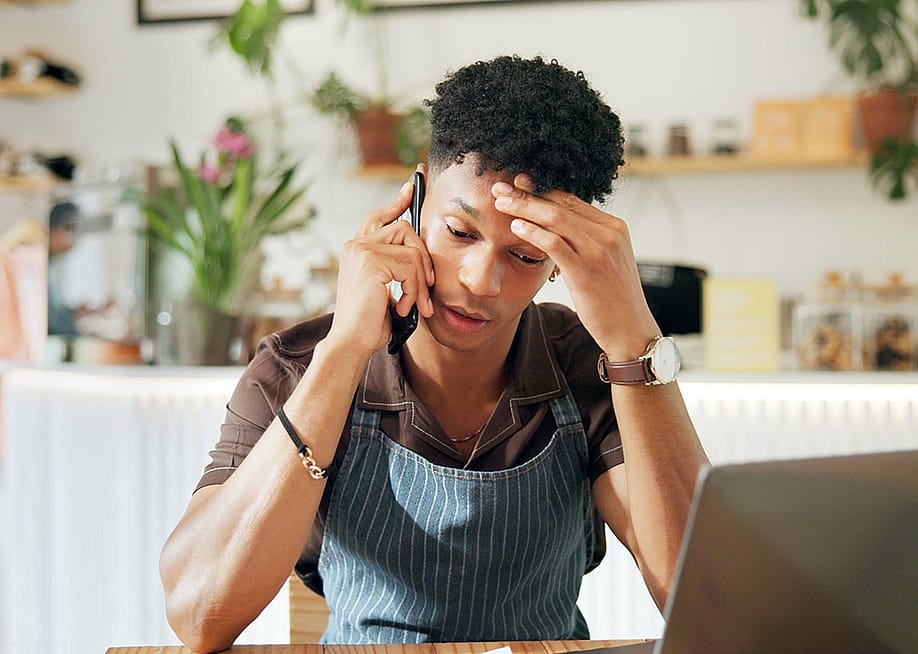 A business owner appearing to be frustrated while on a call because of loan application woes. — PeopleImages // Shutterstock