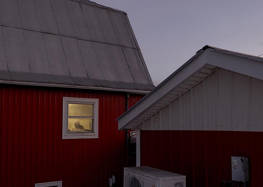 A worker can be seen by the window of one of the dairy farm properties at Pleasant Valley Farms in Vermont. — Anna Watts