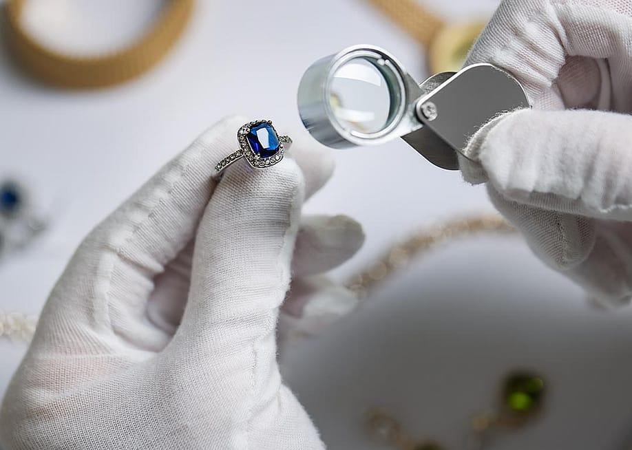 An appraiser inspecting a blue diamond ring. — New Africa // Shutterstock