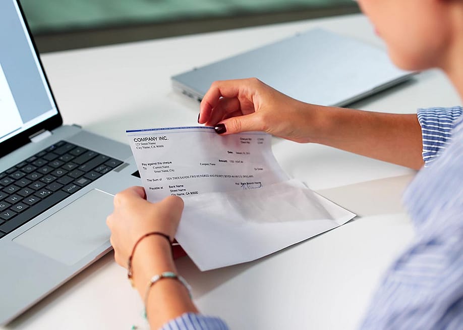 A payroll officer reviewing a compensation check. — Andrey_Popov // Shutterstock