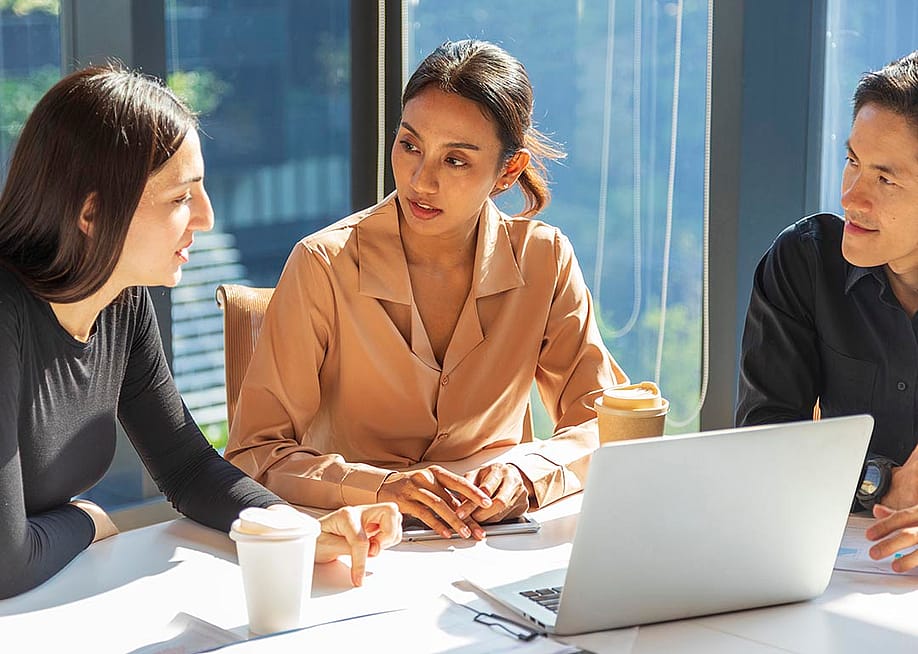 A small group of employees discussing work-related matters during a meeting. — ben bryant // Shutterstock