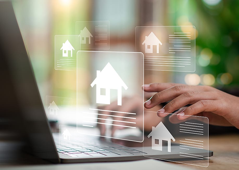 Digital real estate listing graphics over an agent using a laptop. — chaylek // Shutterstock