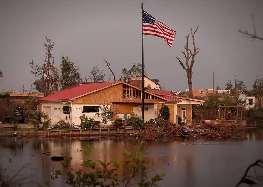 A new American flag pole standing outside a damaged Forest Lake house after the 2011's EF4 tornado in Tuscaloosa, Alabama. — Carmen K. Sisson // Shutterstock