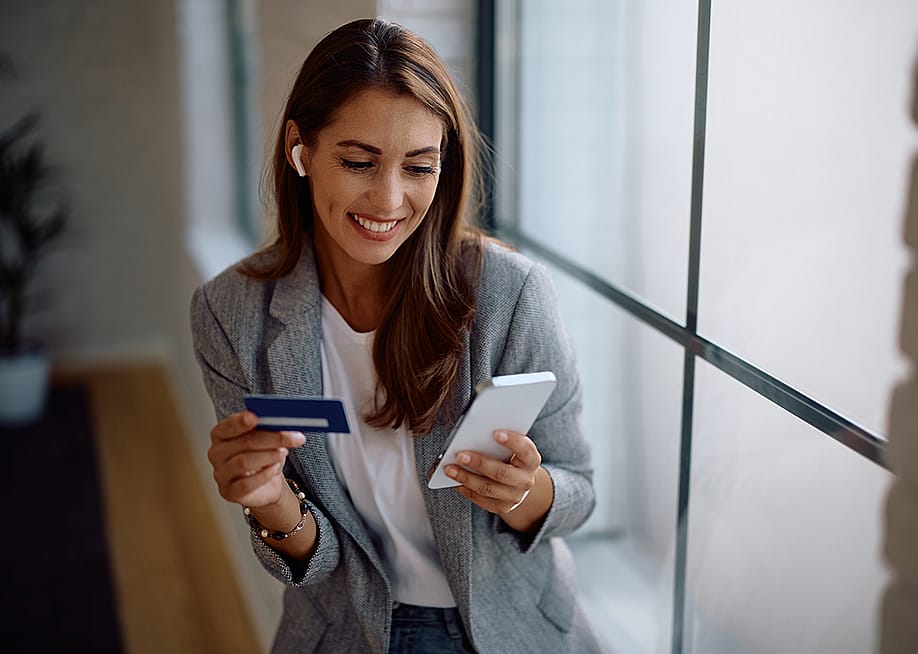 A female entrepreneur paying an online purchase with a credit card. — Drazen Zigic // Shutterstock