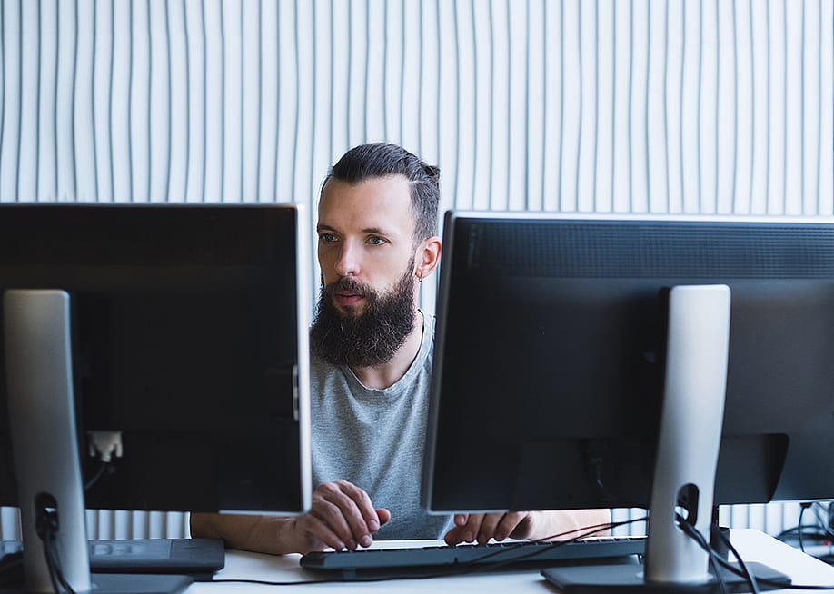 A software engineer working on a quality assurance task in an office. — Golubovy // Shutterstock