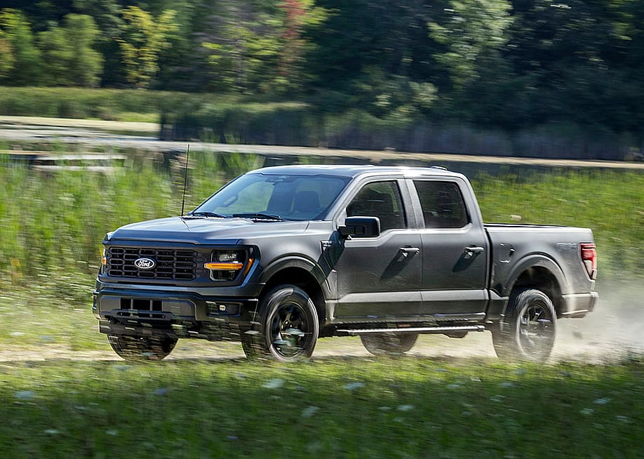 A black Ford F-150 pickup truck on the road. — Ford