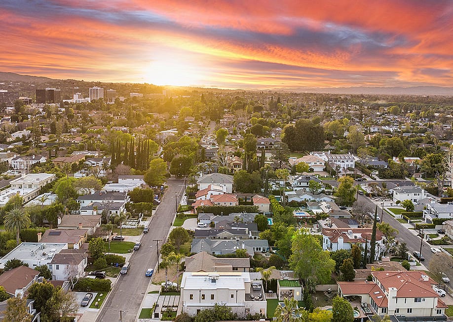 Aerial view of a suburban neighborhood at sunset. — Wirestock Creators // Shutterstock
