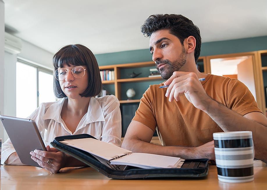 A young couple reviews and pays bills online using a digital tablet. — Mix Tape // Shutterstock