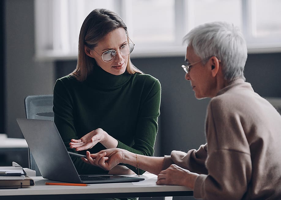 A financial advisor discussing plan options for a life insurance with an elderly client in the office. — G-Stock Studio // Shutterstock