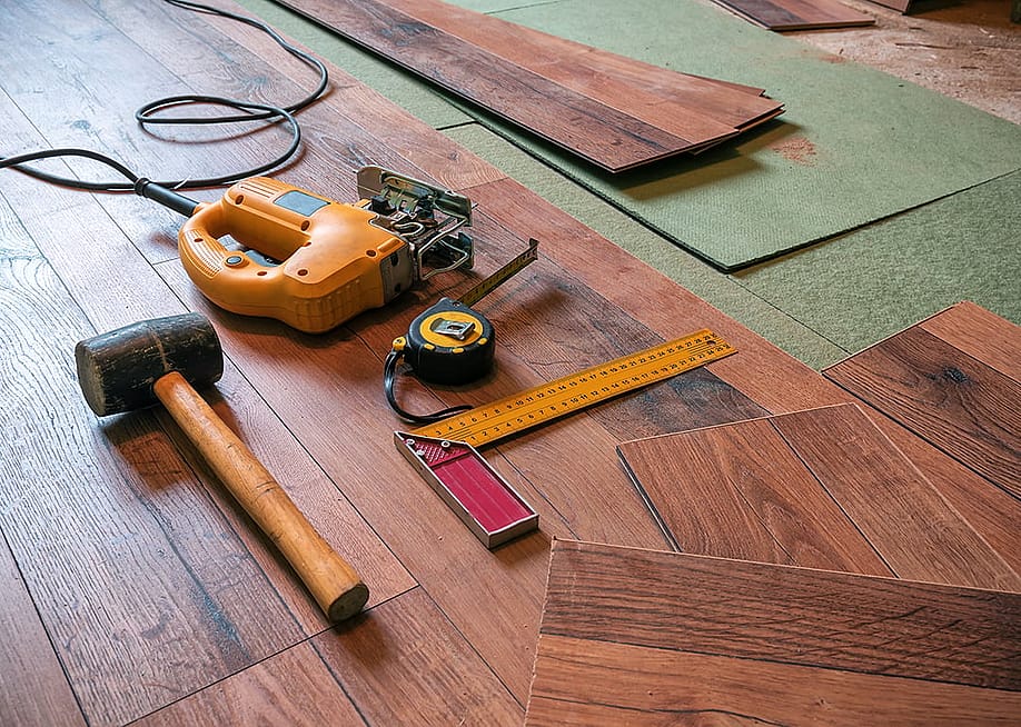 A rubber hammer, an electrofret, and a joiner angle gathered on a laminated floor. — Vova Shevchuk // Shutterstock