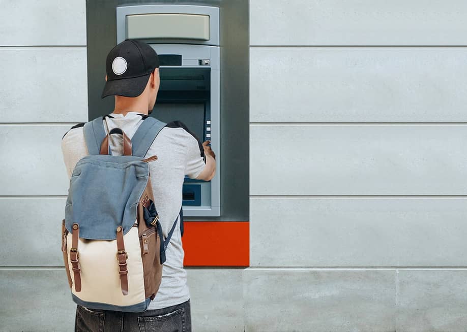 A tourist withdraws from an ATM. — franz12 // Shutterstock