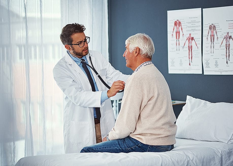 A doctor assessing an elderly person's breathing with a stethoscope during a medical check-up. — PeopleImages // Shutterstock