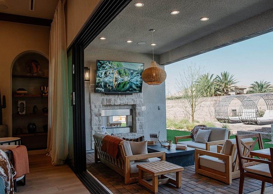 A modern covered patio in a backyard with extended living area, outdoor television, and fireplace. — Sylvox