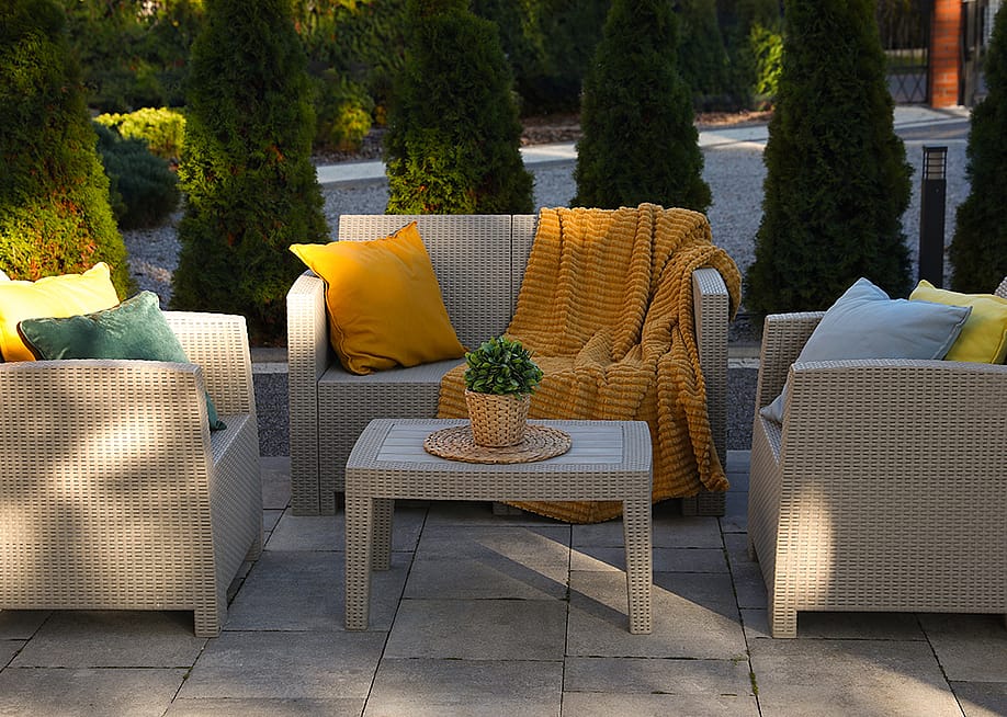 An outdoor rattan garden furniture set with yellow and cream motifs. — New Africa // Shutterstock
