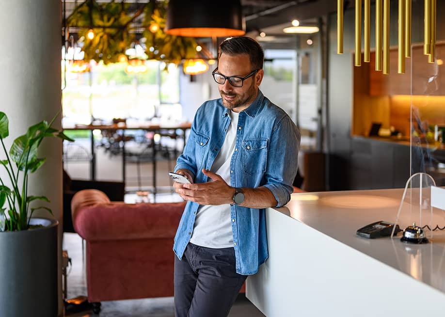 A businessman checking social media from his smartphone for their business' marketing. — Moon Safari // Shutterstock