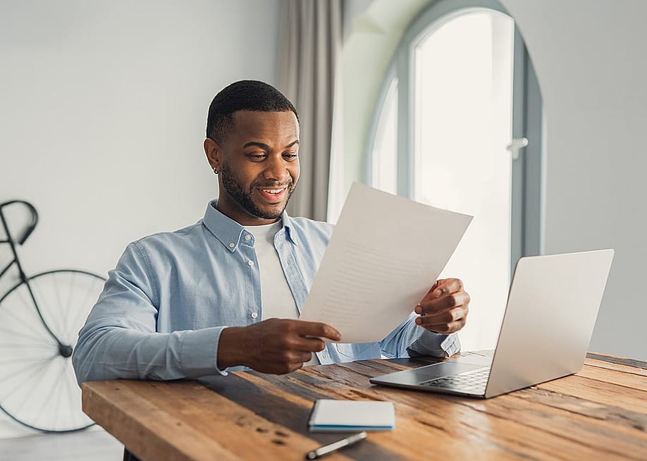 A young adult reading an important letter of his personal achievement at work. — PerfectWave // Shutterstock