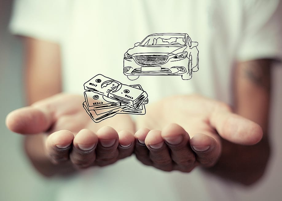 Person holding over an illustration of cars and money as a concept of insurance. — ArtVibe1 // Shutterstock