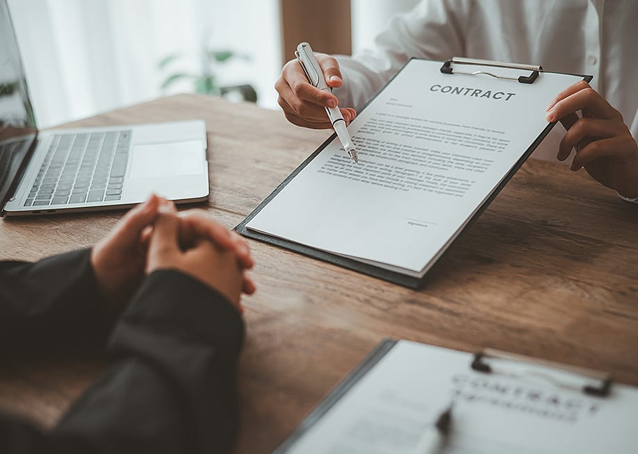 A business partner explaining agreements and matters from a contract to her co-partner. — photobyphotoboy // Shutterstock