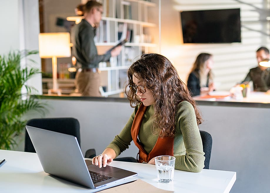 A young female entrepreneur working quietly in a modern office space. — Nikita Sursin // Shutterstock