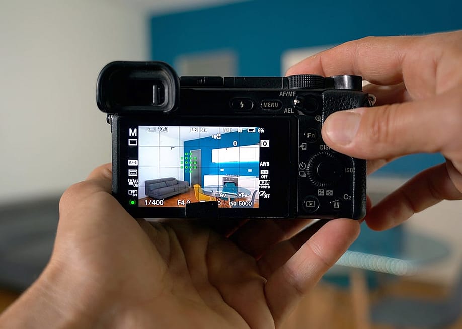 Person professionally taking a photograph of a home's interior. — DELBO ANDREA // Shutterstock
