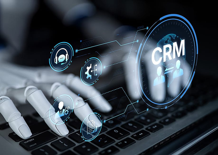 A robot enhancing CRM automation analytics and tools with artificial intelligence from a laptop. — Summit Art Creations // Shutterstock