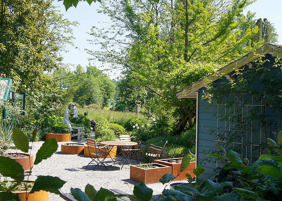 A lovely garden space with outdoor seating area and a garden shed. — ThePhotoFab // Shutterstock