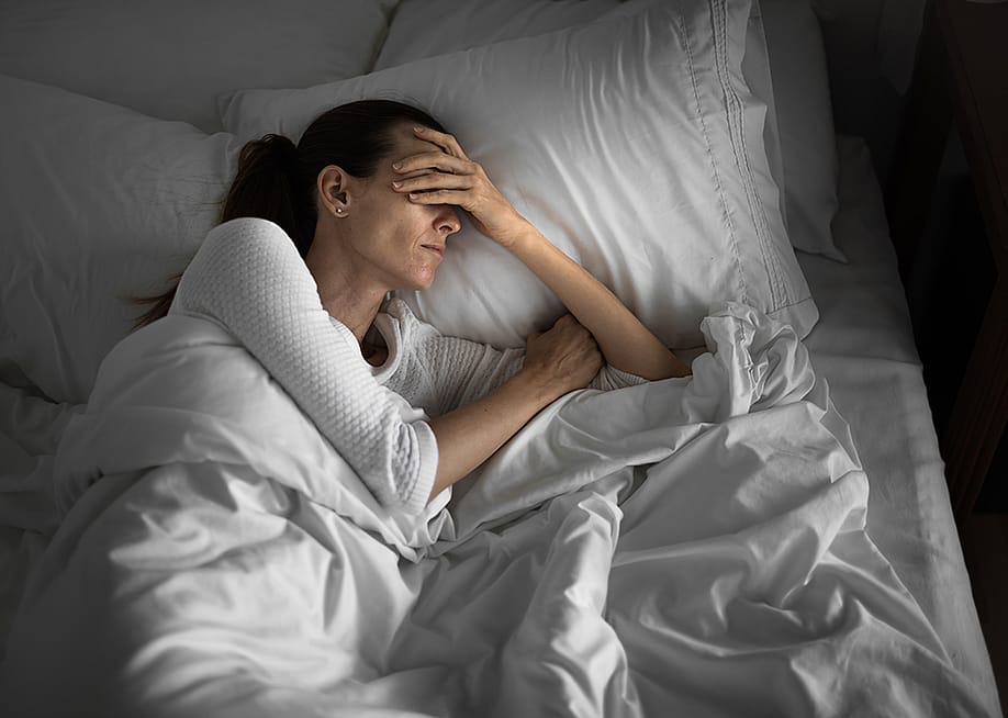 A tired woman in bed struggling to sleep. — KieferPix // Shutterstock