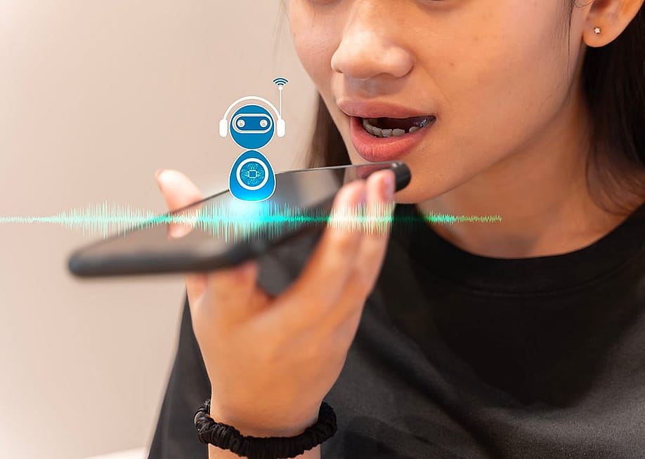 A young woman talking into a smartphone with AI voice assistance. — jittawit21 // Shutterstock