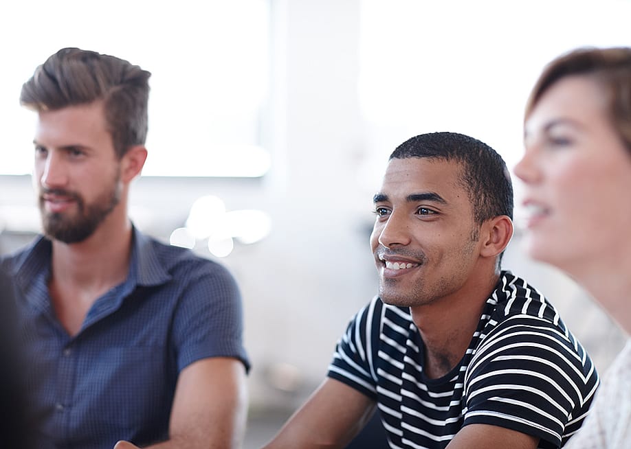 Office employees listening during a workshop session about team development in the workplace. — PeopleImages // Shutterstock