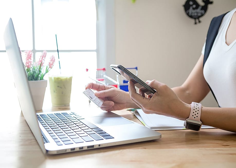A person checking her credit card's details for a digital transaction from online shopping. — LittlePigPower // Shutterstock