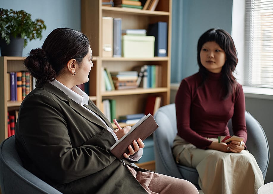 An Asian teenage girl in a counseling session with a female therapist. — SeventyFour // Shutterstock