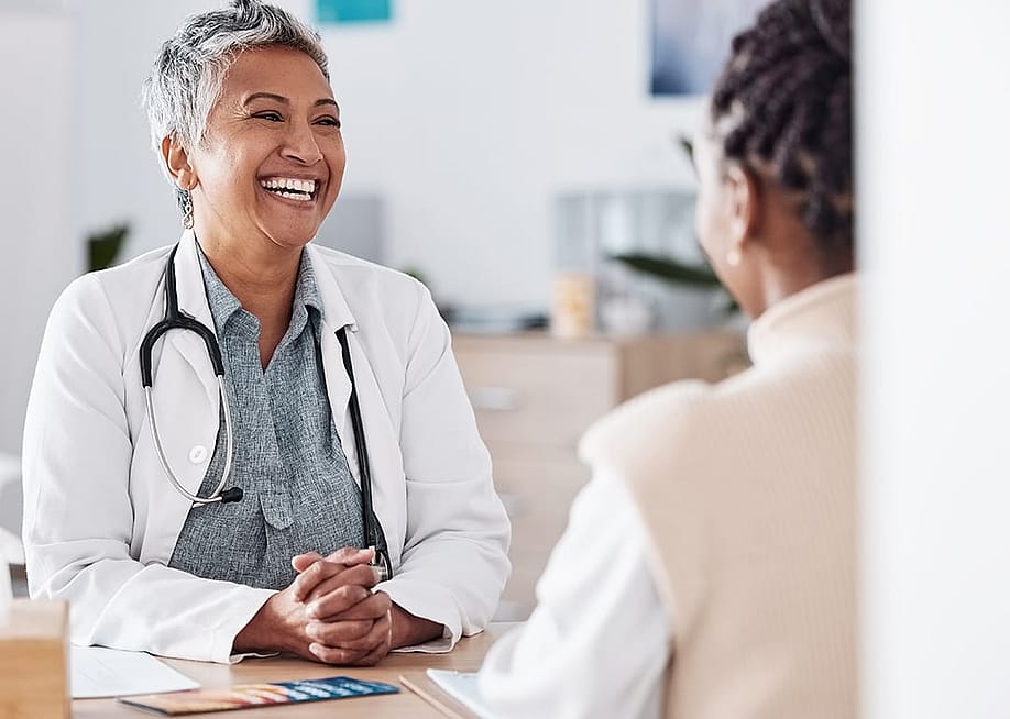 A female doctor happily engaged in a discussion with a patient. — PeopleImages // Shutterstock