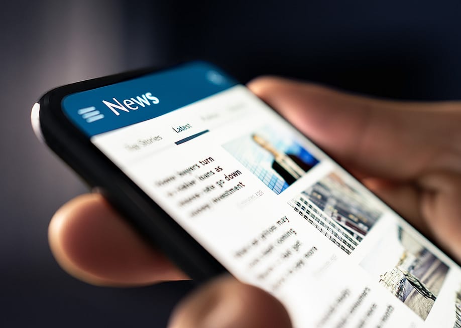 A person reading headlines from a news website online in his smartphone. — Tero Vesalainen // Shutterstock